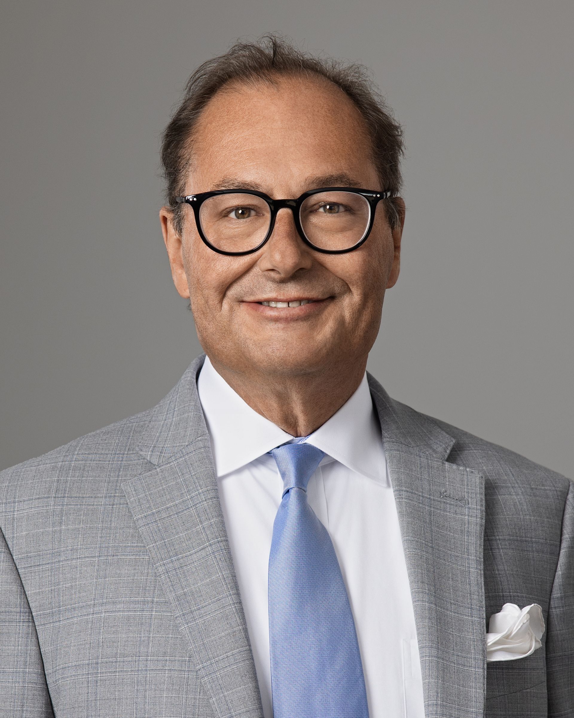 A man in a suit and tie is smiling for the camera.