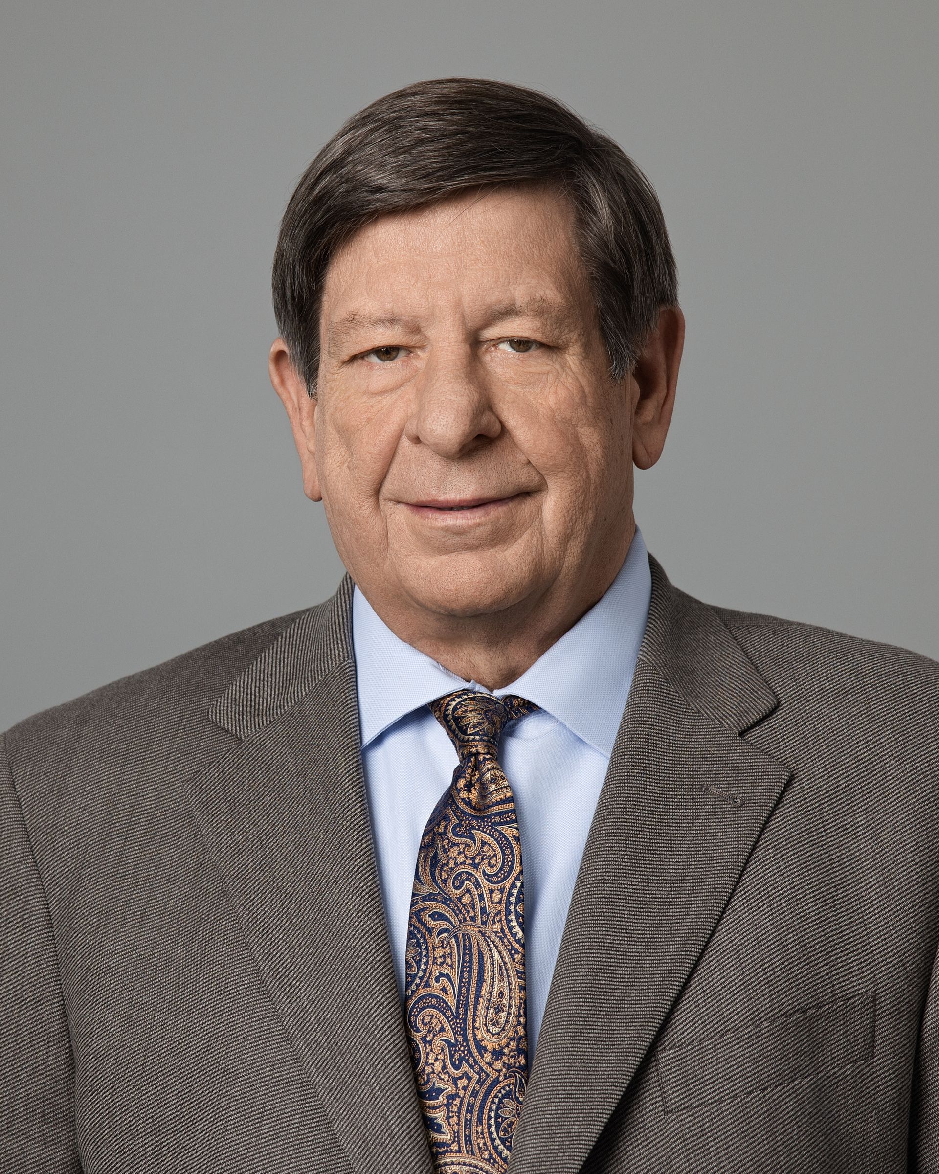 A man in a suit and tie is smiling for the camera