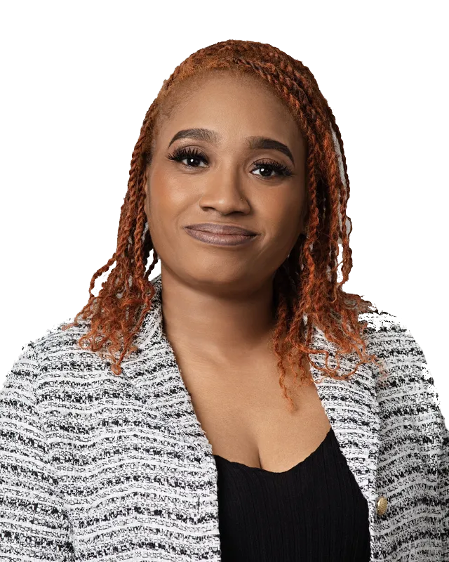 A woman with red hair is wearing a black top and a white jacket.