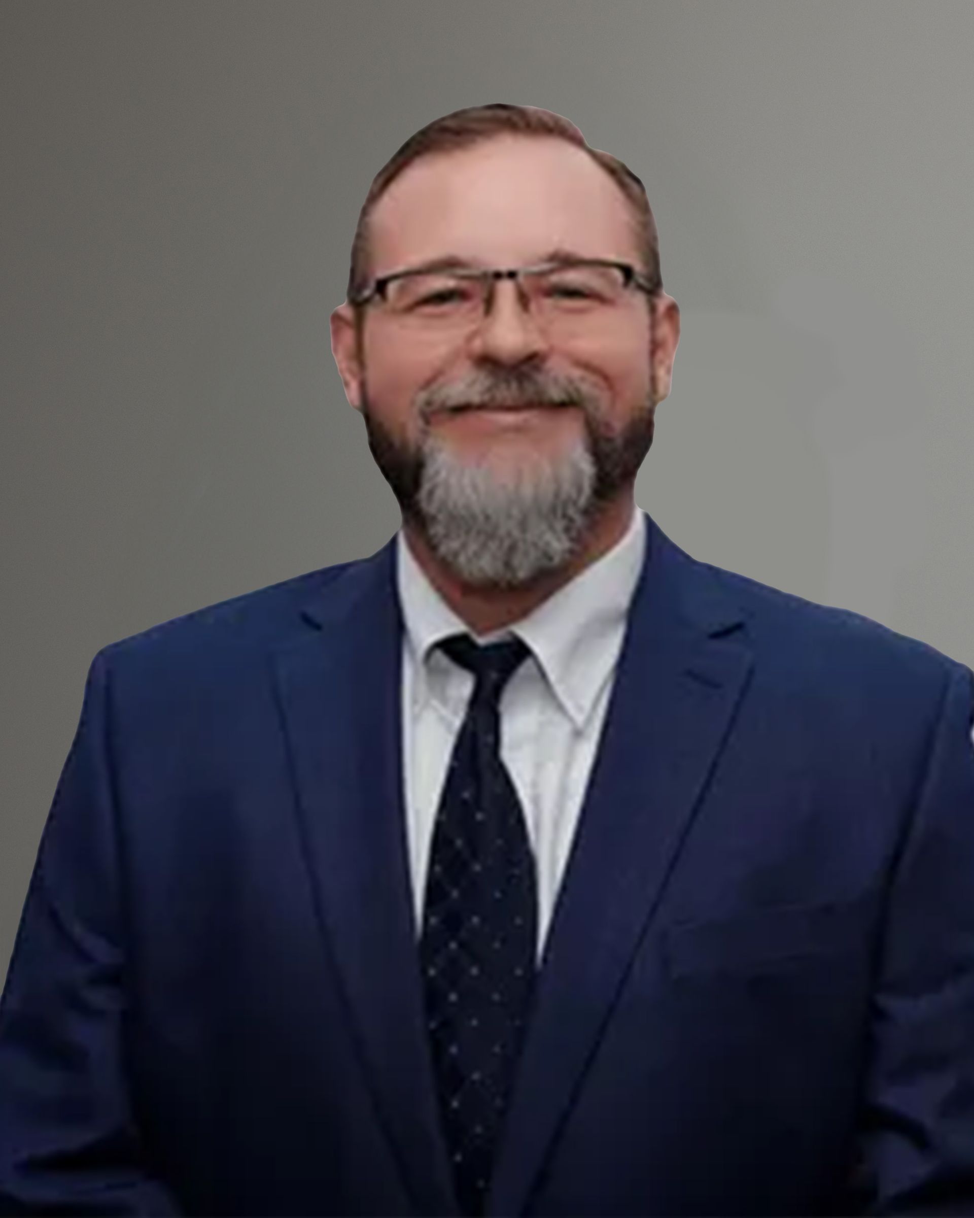 A man with a beard and glasses is wearing a blue suit and tie