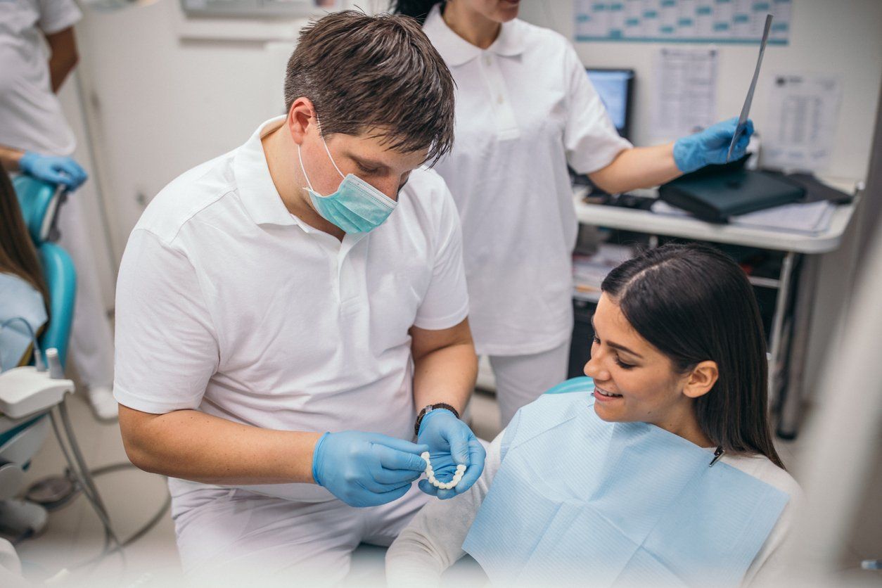 A woman reviewing dental implants with the dentist.