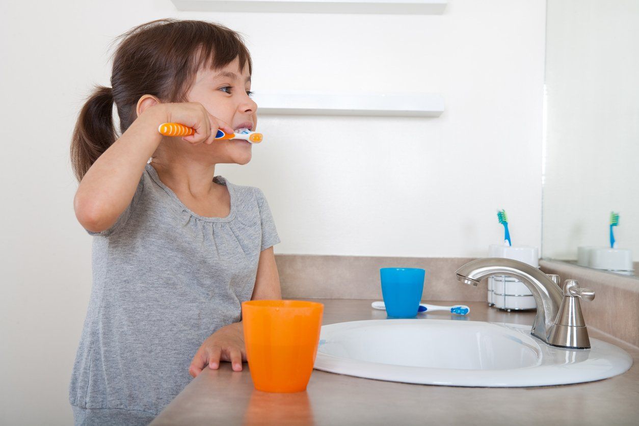 child brushing her teeth in anticipation of the tooth fairy