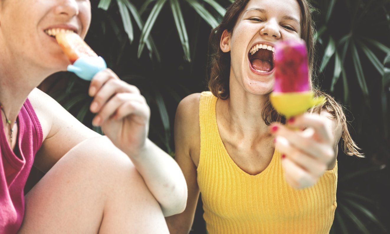 eating a fruit popsicle as an alternative to ice cream to maintain oral health over the summer