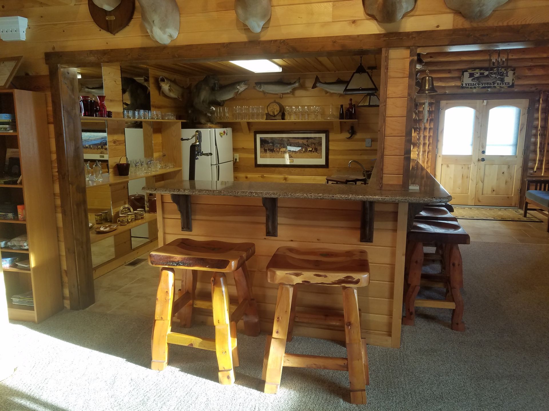A kitchen in a log cabin with a bar and stools