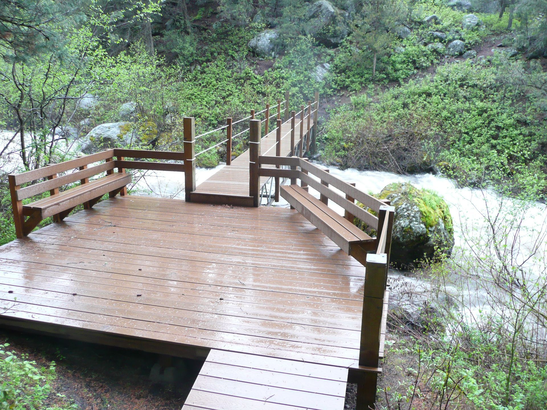 A wooden bridge over a river in the woods