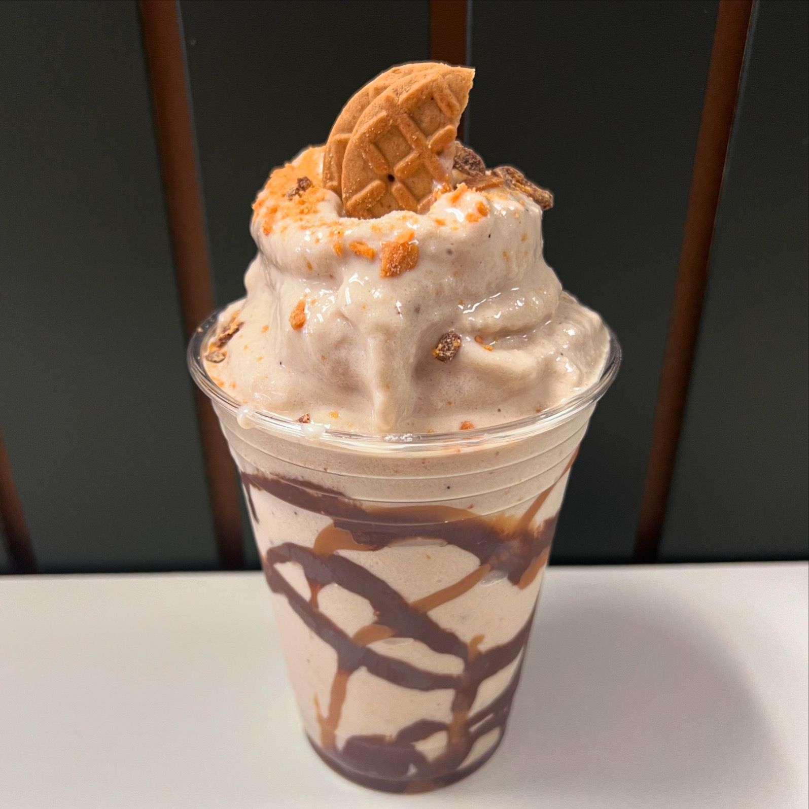 A close up of a milkshake with a waffle cone on top.
