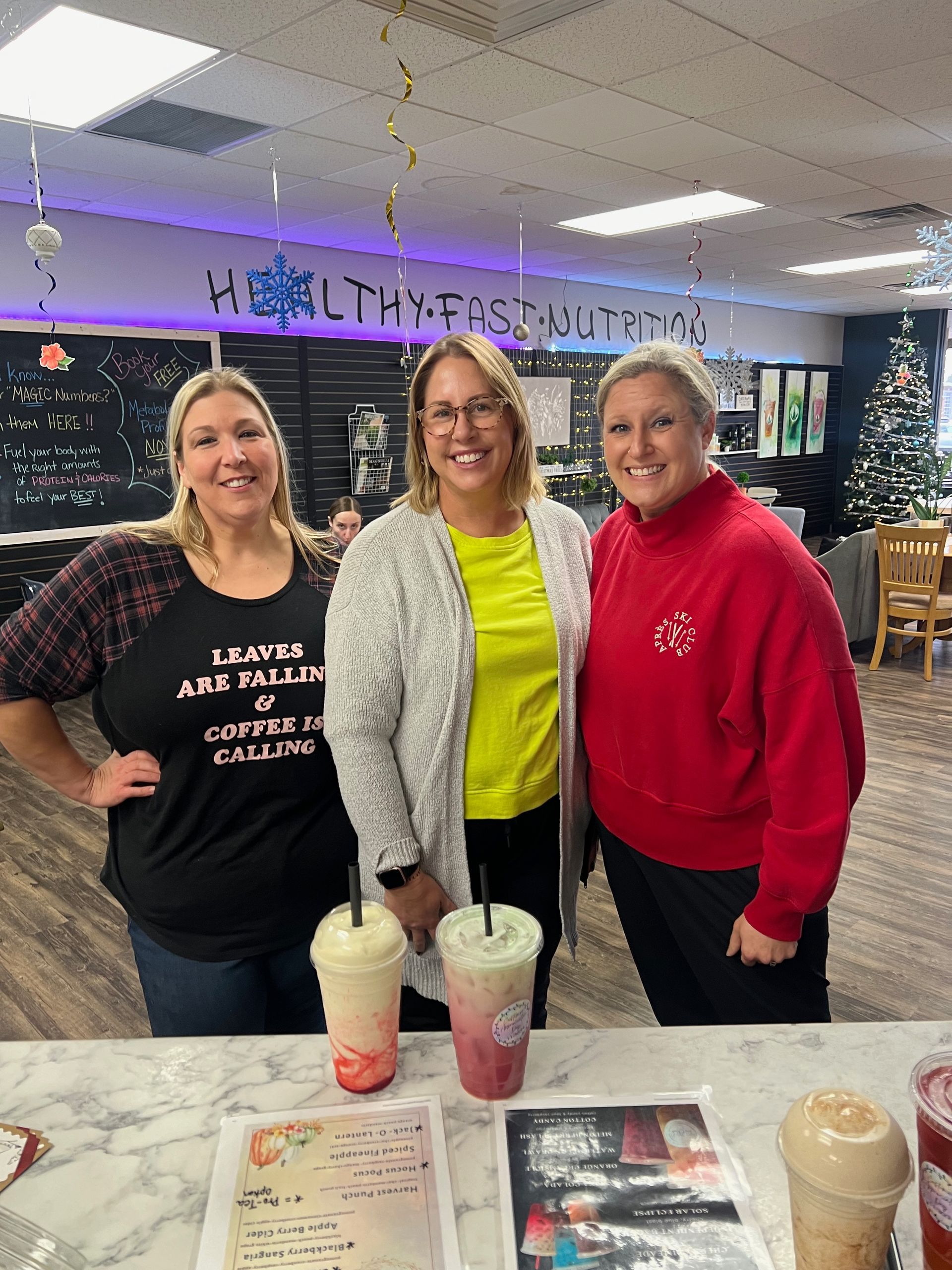 Three women are posing for a picture in a restaurant.
