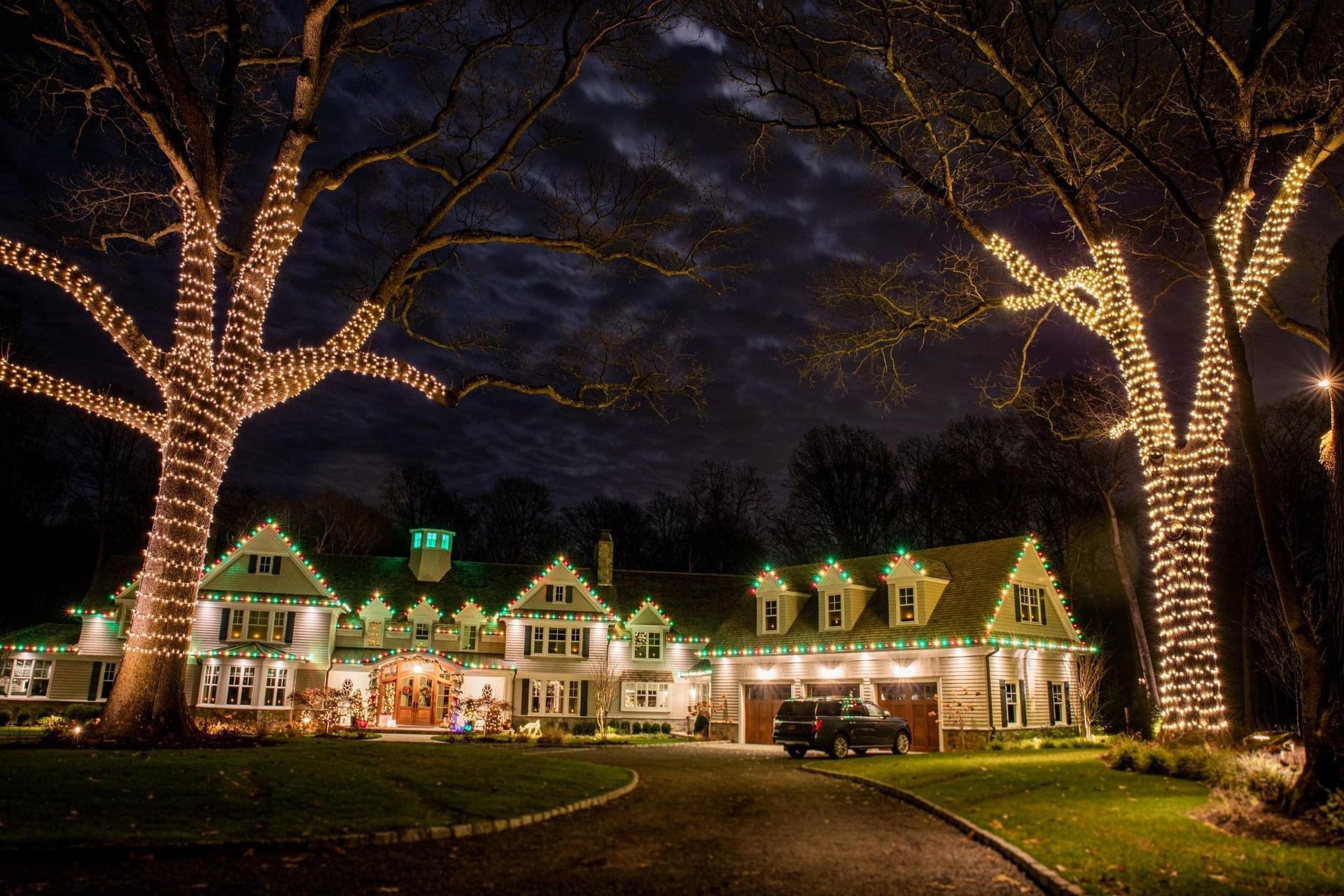 Front view of a house decorated with bright, colorful Christmas lights and holiday decorations.