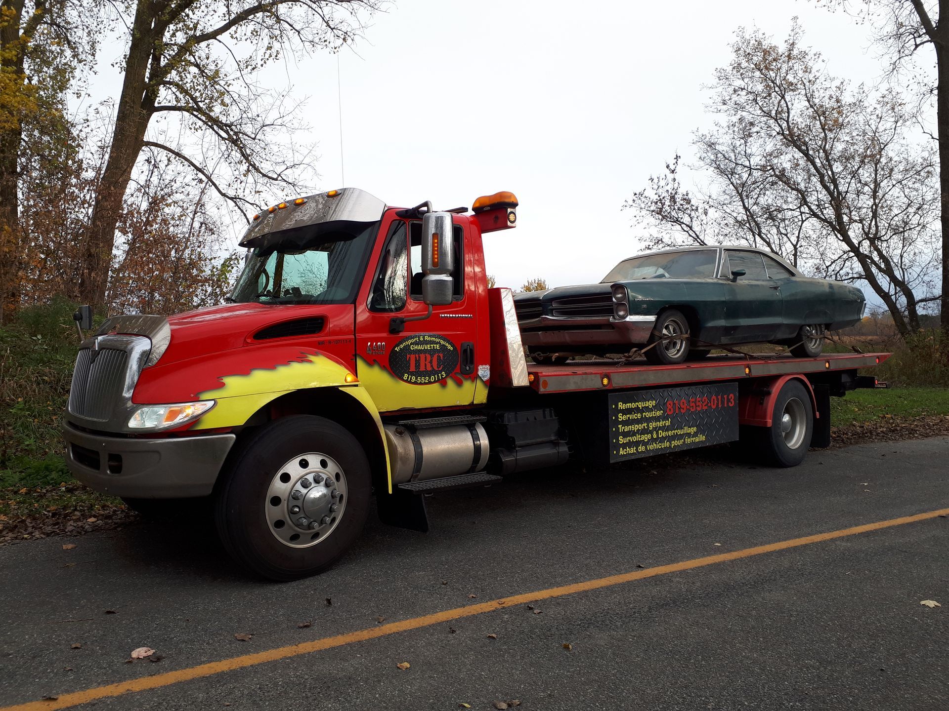 Parquet clair récemment installé dans une pièce avec une fenêtre, des murs non finis et un pied de biche rouge.