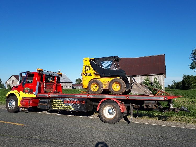 Parquet clair récemment installé dans une pièce avec une fenêtre, des murs non finis et un pied de biche rouge.