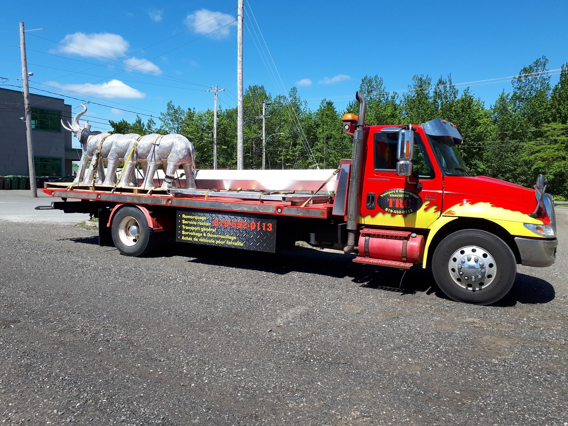 Parquet clair récemment installé dans une pièce avec une fenêtre, des murs non finis et un pied de biche rouge.