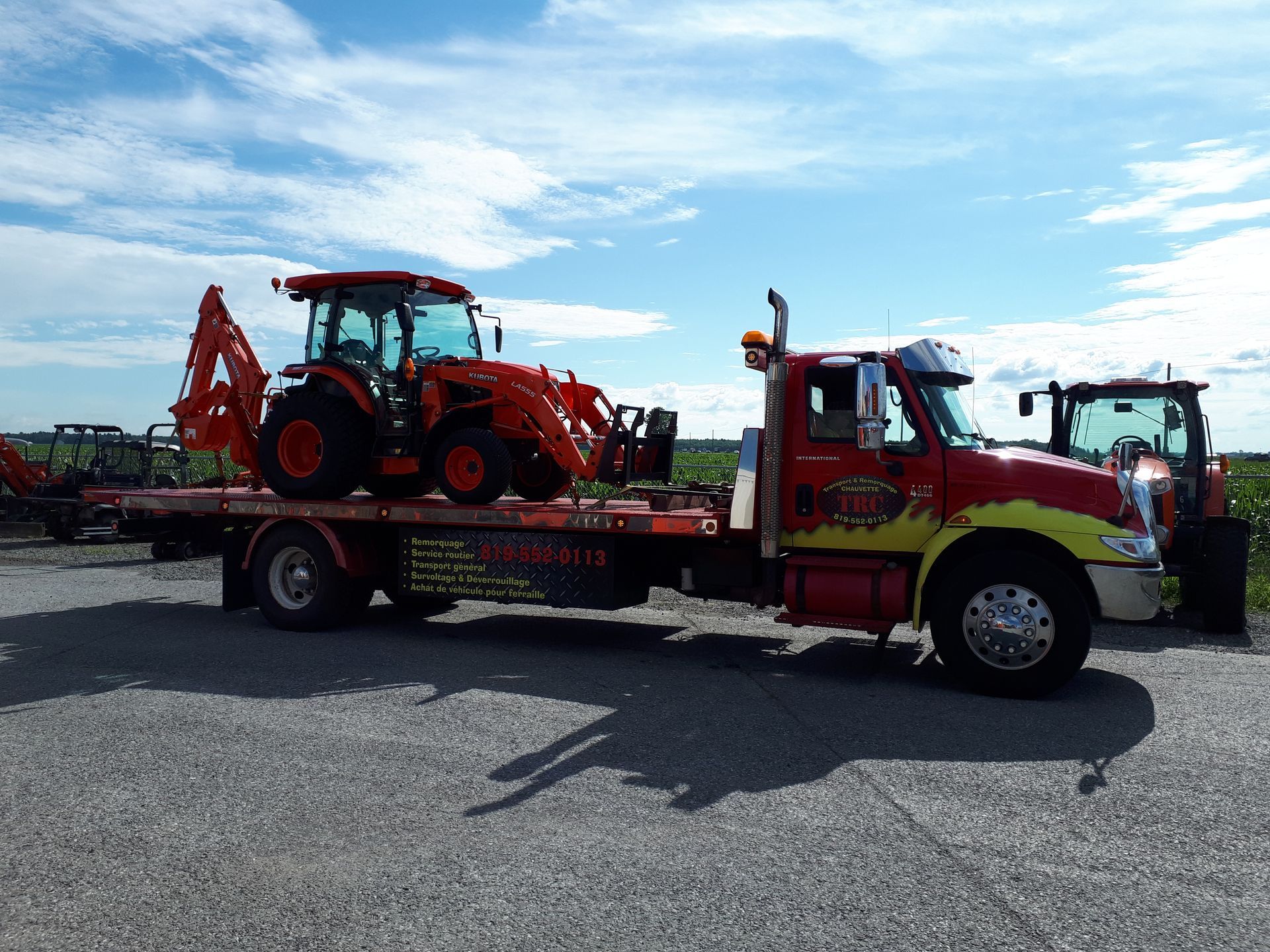 Parquet clair récemment installé dans une pièce avec une fenêtre, des murs non finis et un pied de biche rouge.