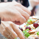 A group of people sitting around a conference table in an office, discussing a digital presentation.