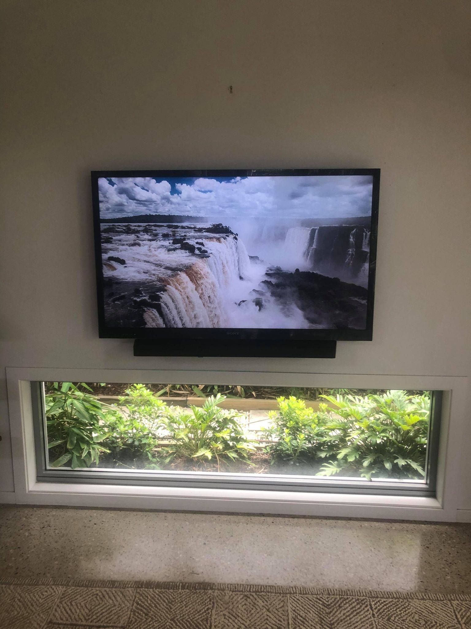 TV Displaying Waterfalls Above a Window With a View of Greenery — BRC Antenna Service 1 In Banora Point, NSW
