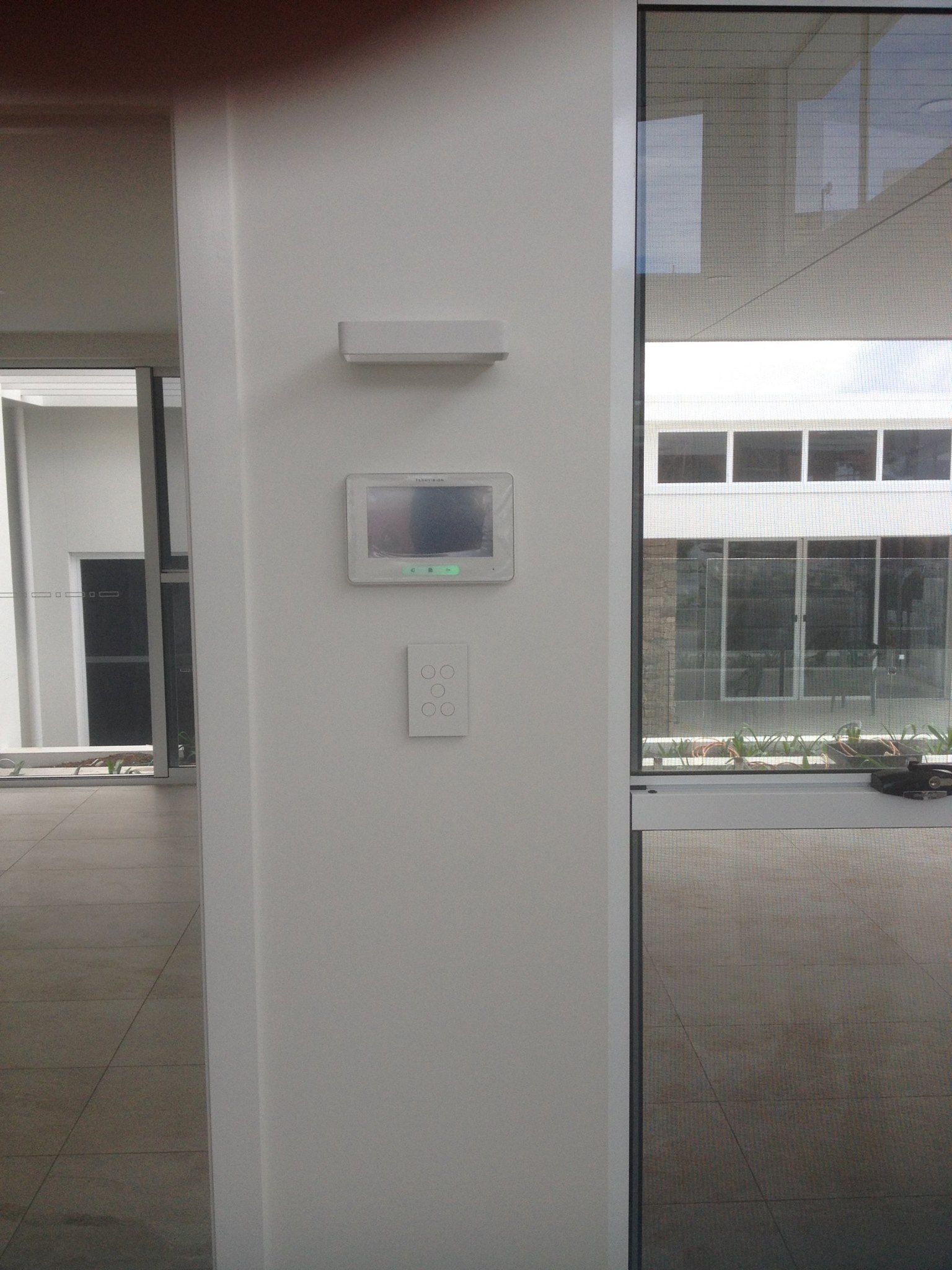 White Wall With a Rectangular Touch Screen, Light Fixture, and Outlet — BRC Antenna Service 1 In Banora Point, NSW