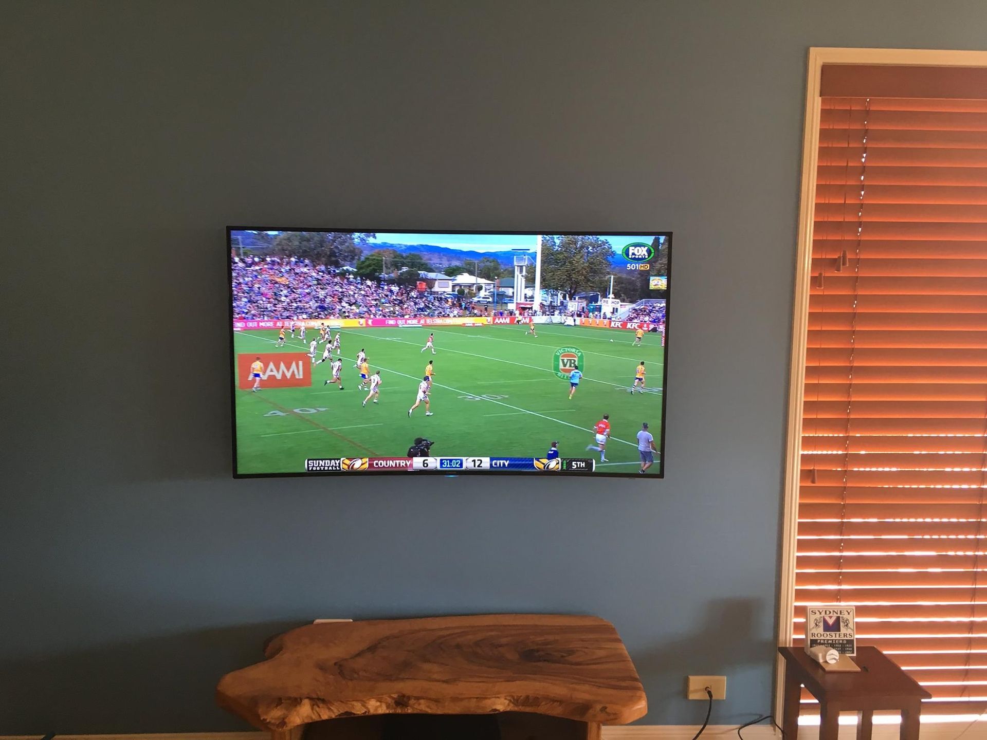 Television Mounted on a Blue Wall, Showing a Sports Game — BRC Antenna Service 1 In Ballina, NSW