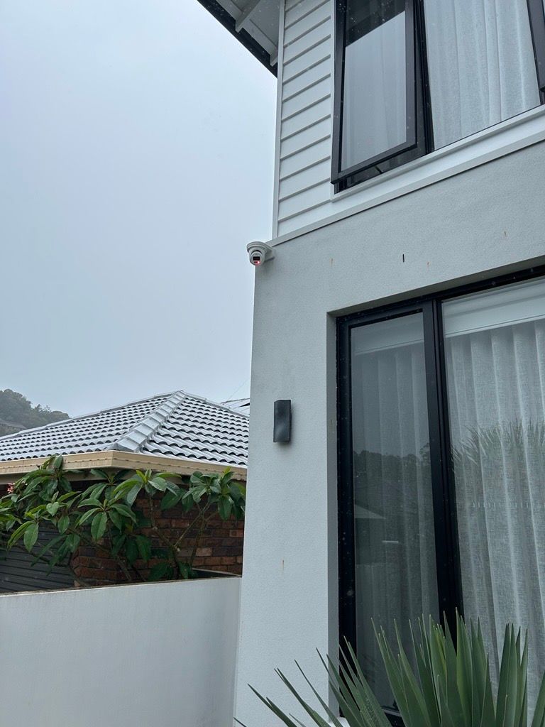 Hand Entering Code on a White Security System Keypad Mounted on a Grey Wall — BRC Antenna Service 1 In Kingscliff, NSW