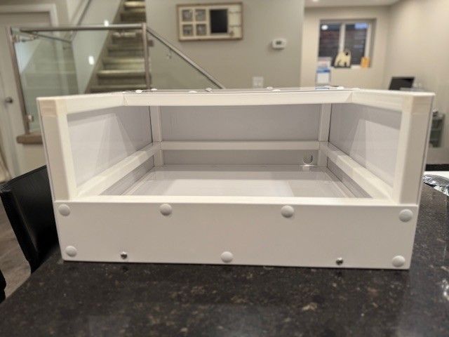 White rectangular enclosure with rounded corners, sitting on a dark countertop.