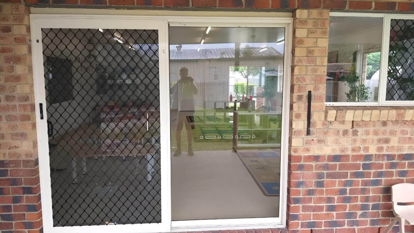 White Sliding Glass Door With a Security Screen — Hervey Bay Glass Glazing & Screens In Pialba, QLD