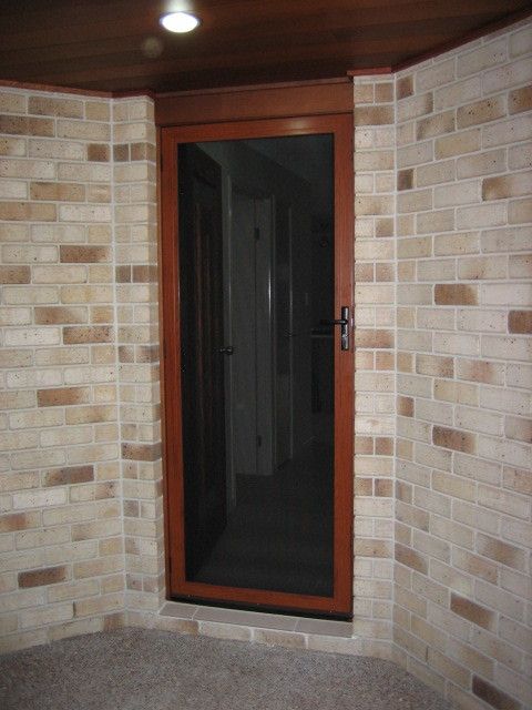 A Brick Wall with A Screen Door in The Corner — Hervey Bay Glass Glazing & Screens In Pialba, QLD