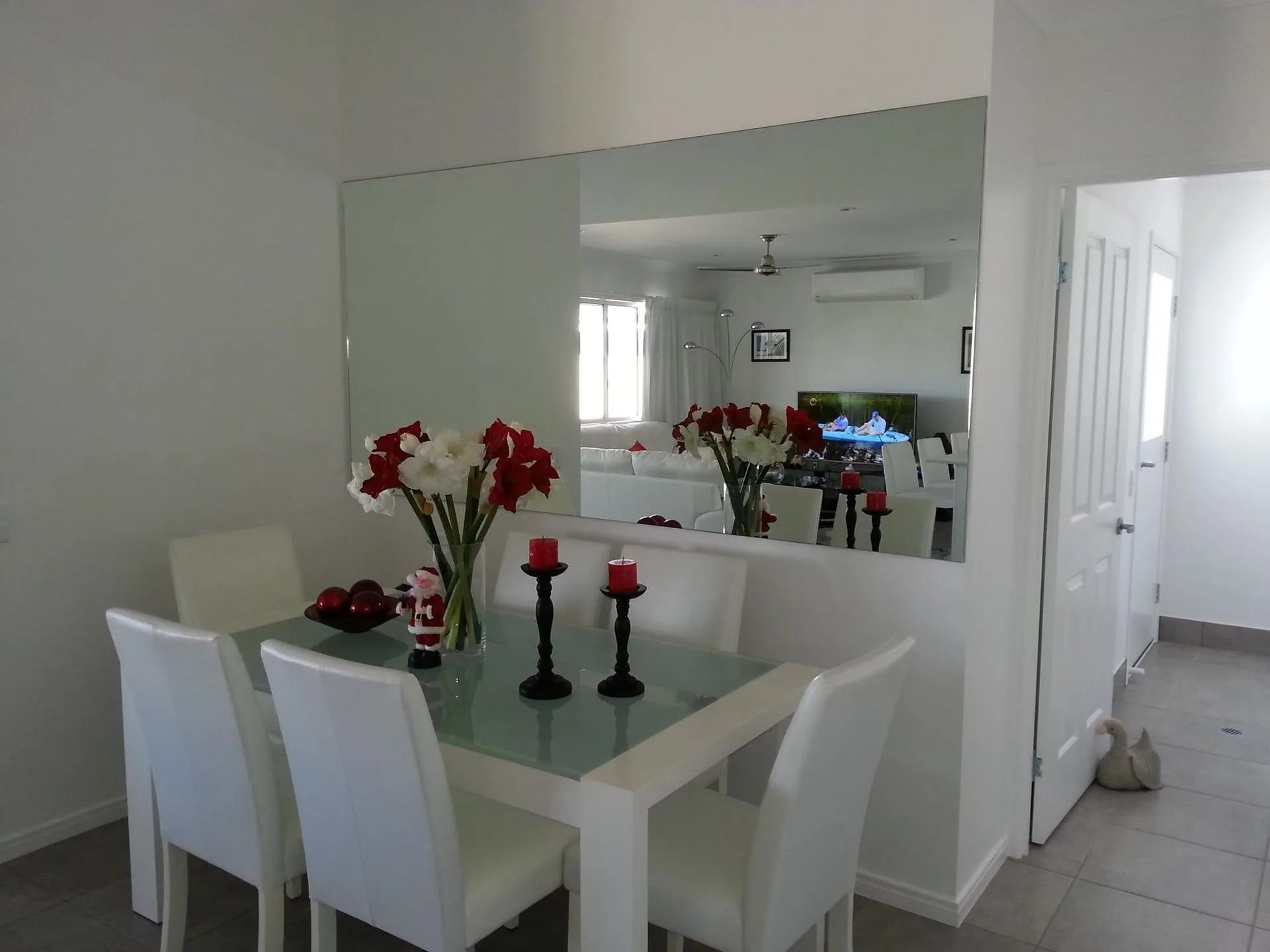 A Dining Room with A Table and Chairs and A Large Mirror — Hervey Bay Glass Glazing & Screens In Pialba, QLD