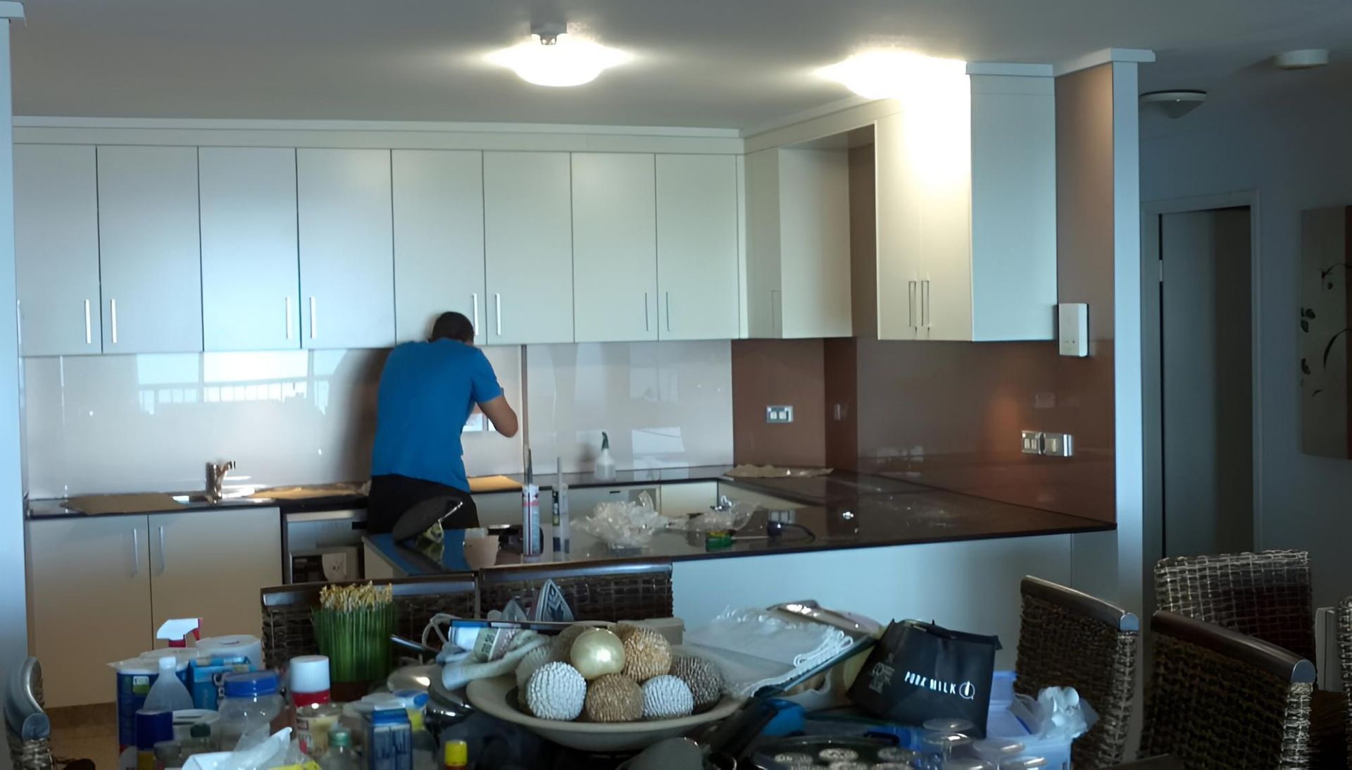 Man Installing Backsplash in Modern Kitchen— Hervey Bay Glass Glazing & Screens In Pialba, QLD
