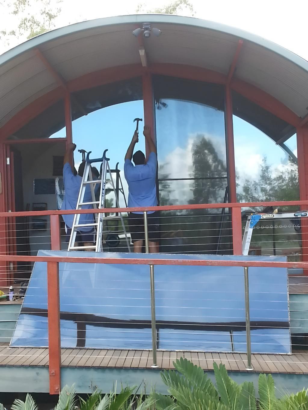 Two Workers Install a Large Curved Window Glass — Hervey Bay Glass Glazing & Screens In Pialba, QLD