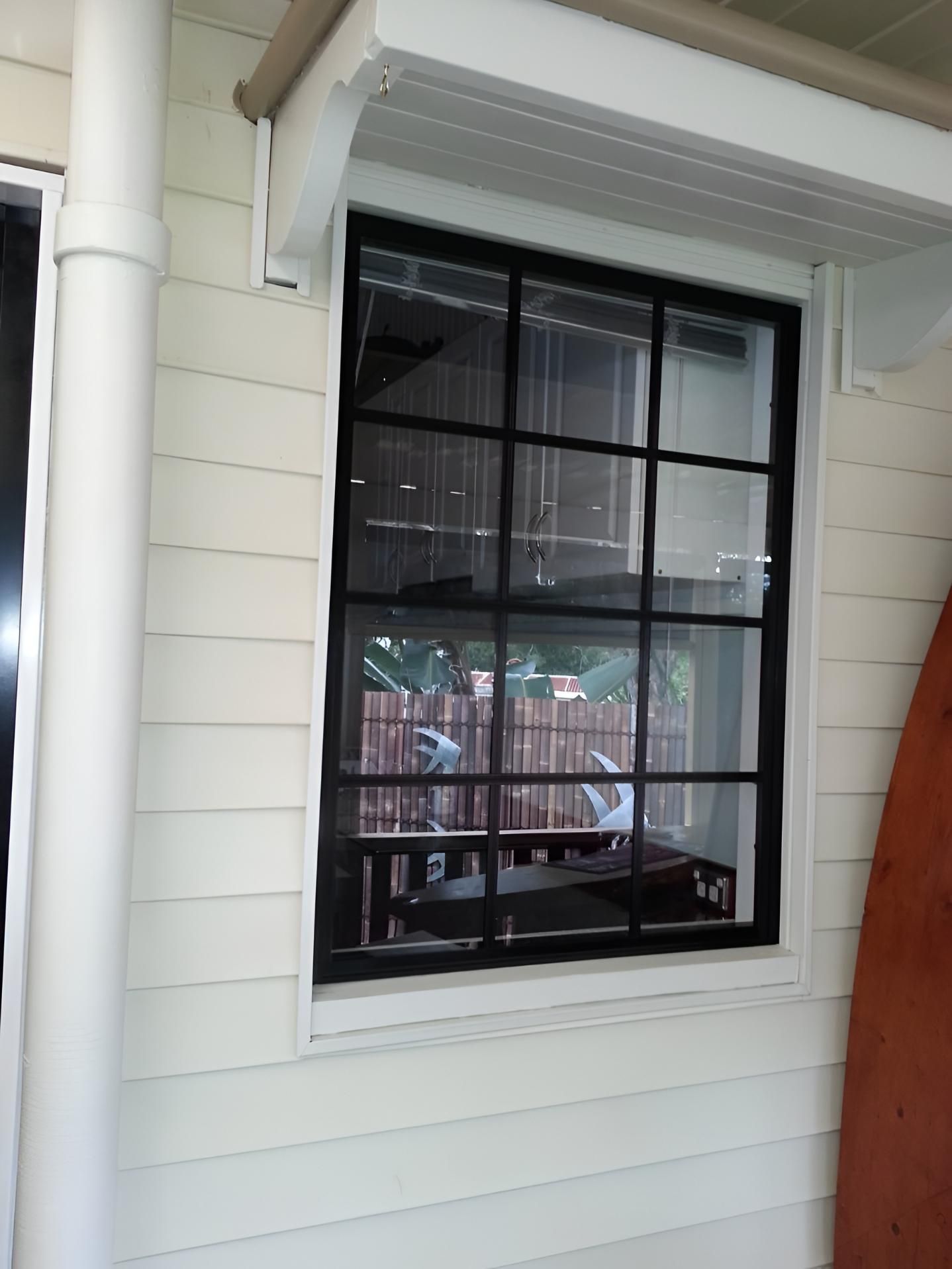 Glass Window With a Reflection of Yard — Hervey Bay Glass Glazing & Screens In Maryborough, QLD