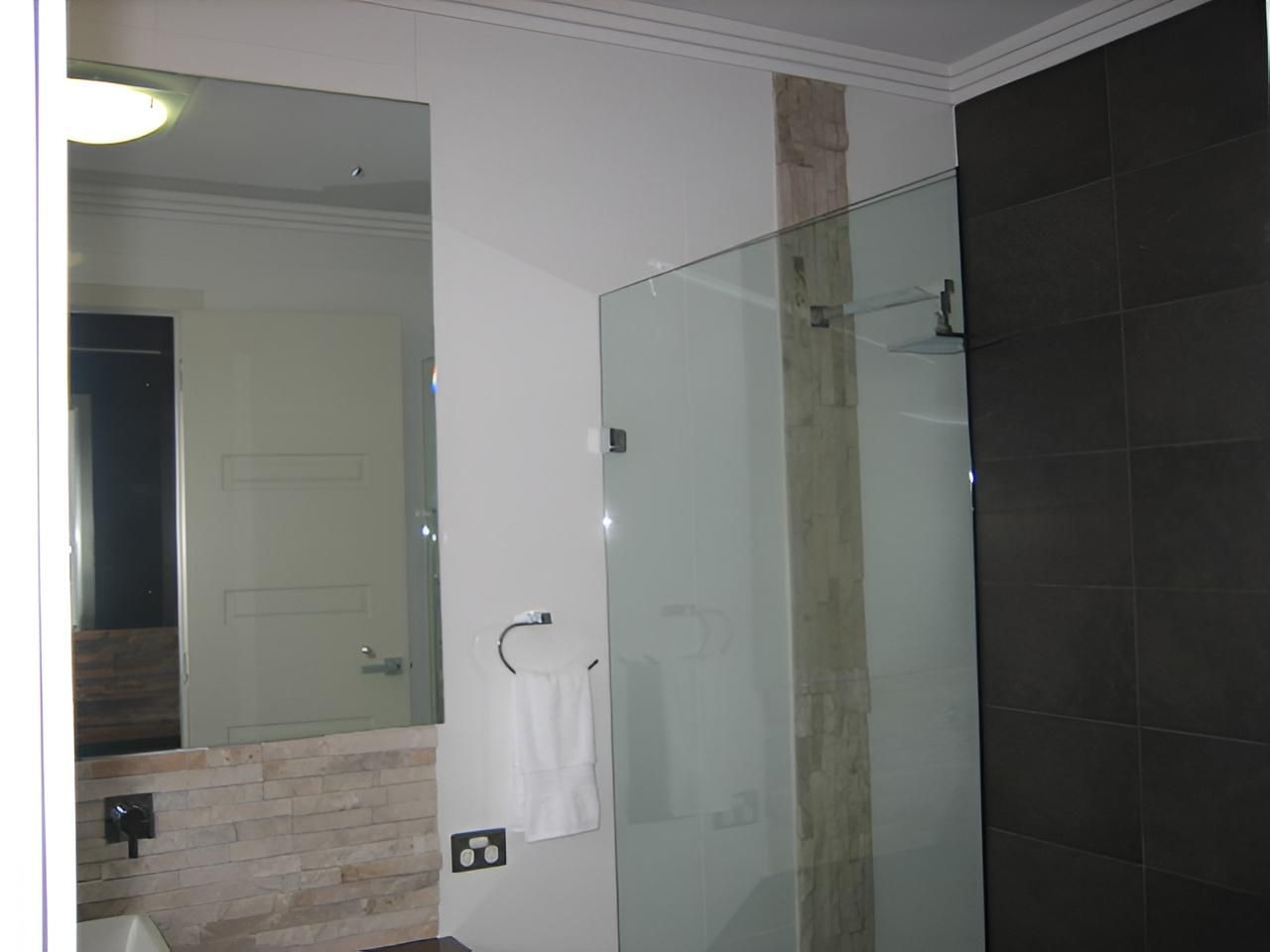 Bathroom With a Large Mirror — Hervey Bay Glass Glazing & Screens In Pialba, QLD