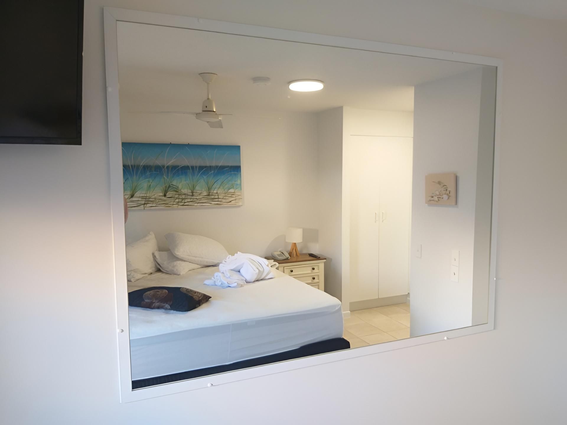 Room With a Mirror and Reflection of Bed — Hervey Bay Glass Glazing & Screens In Maryborough, QLD