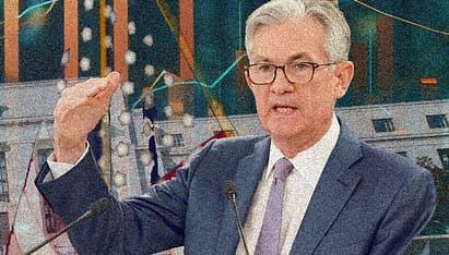 A man in a suit and tie is giving a speech in front of a microphone.