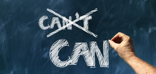 A person is writing on a blackboard that says can 't can