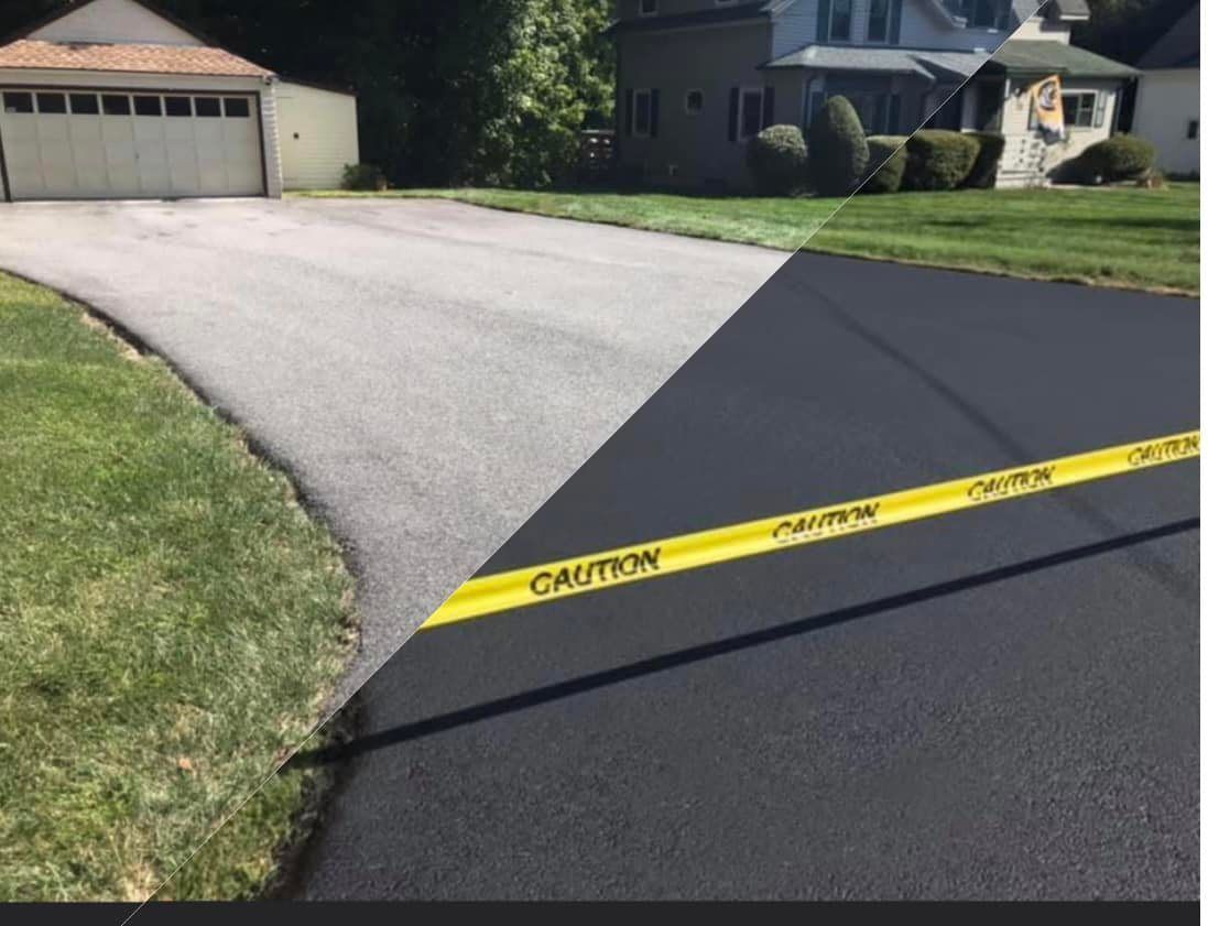 Driveway half-sealed with fresh blacktop, yellow caution tape across the bottom, grass and houses in background.