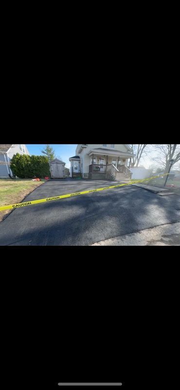 A house with yellow caution tape across the driveway.