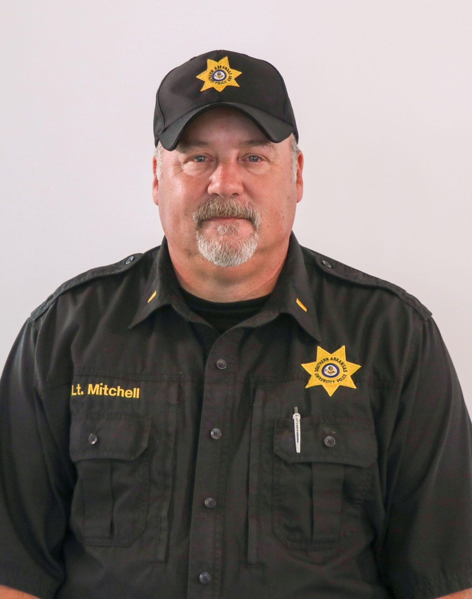 A man in a sheriff 's uniform has the name mitchels on his shirt