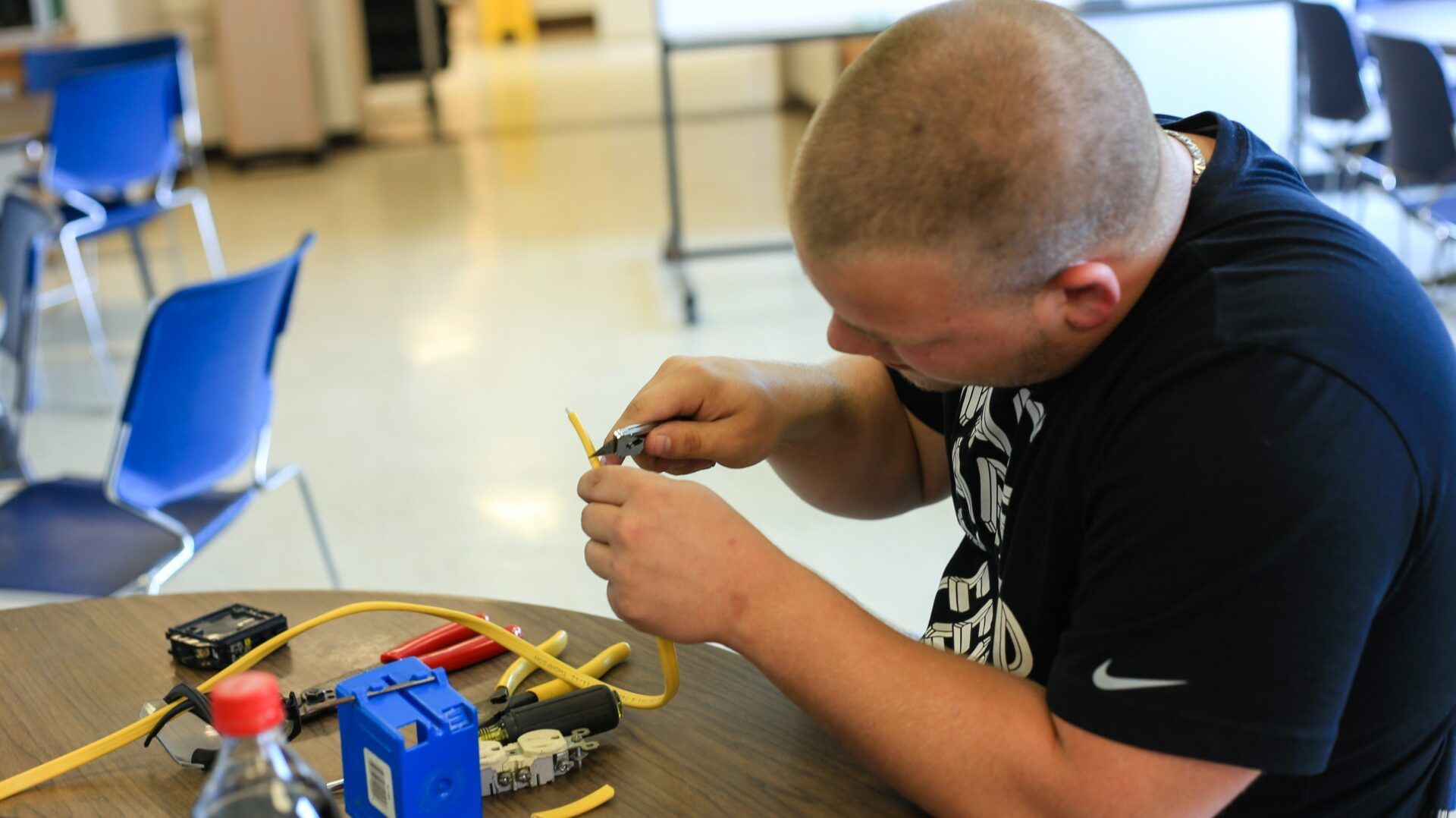 A man is sitting at a table working on a project.