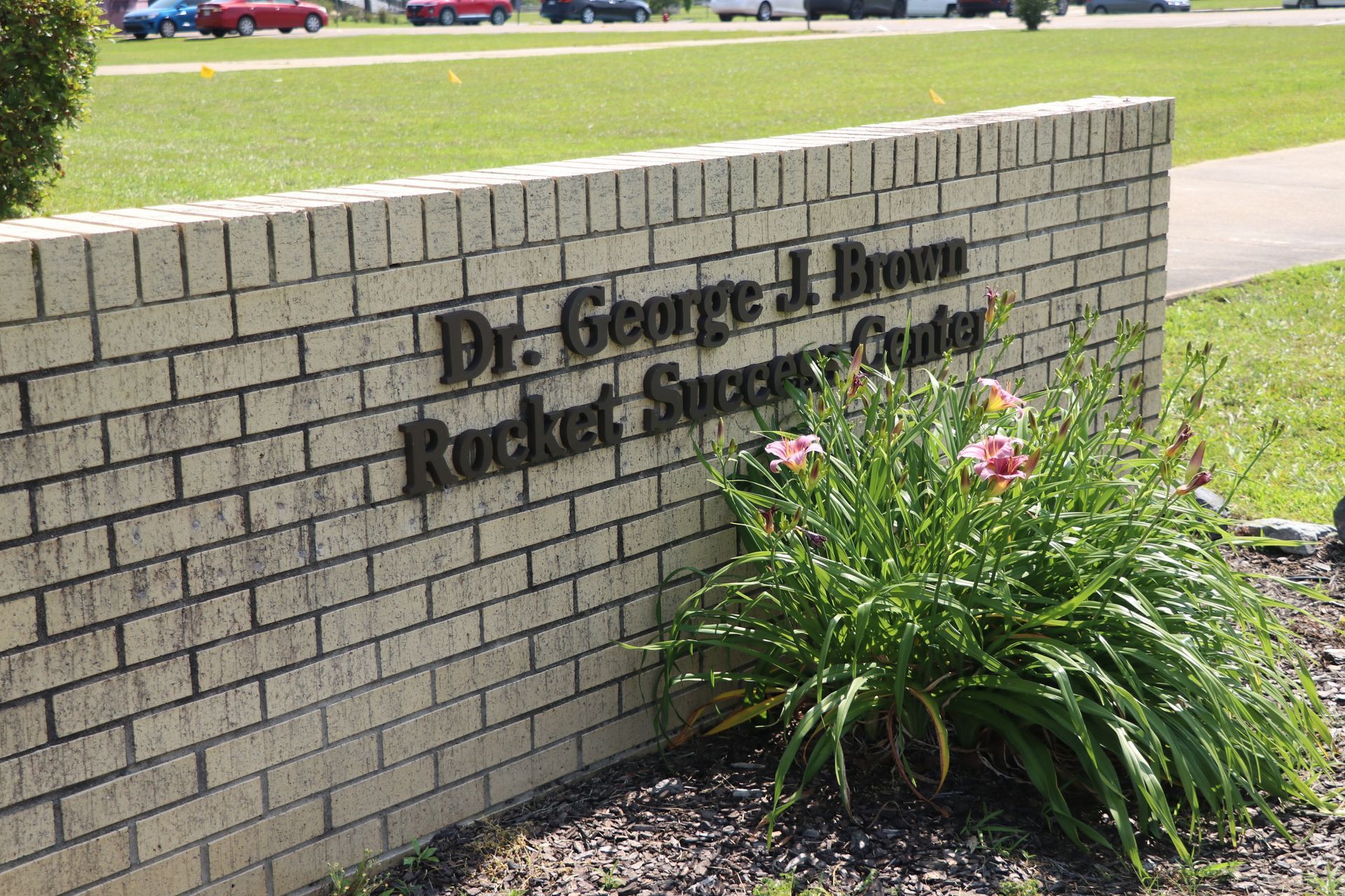 A brick wall with dr. george j. brown rocket success center written on it