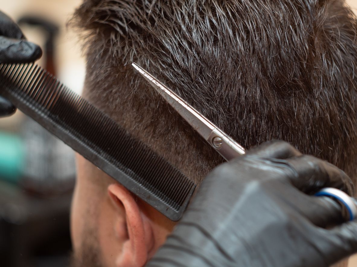 A man is getting his hair cut by a barber.