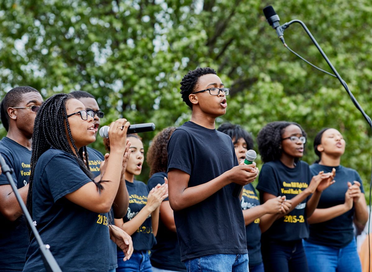A group of young people are singing into microphones.