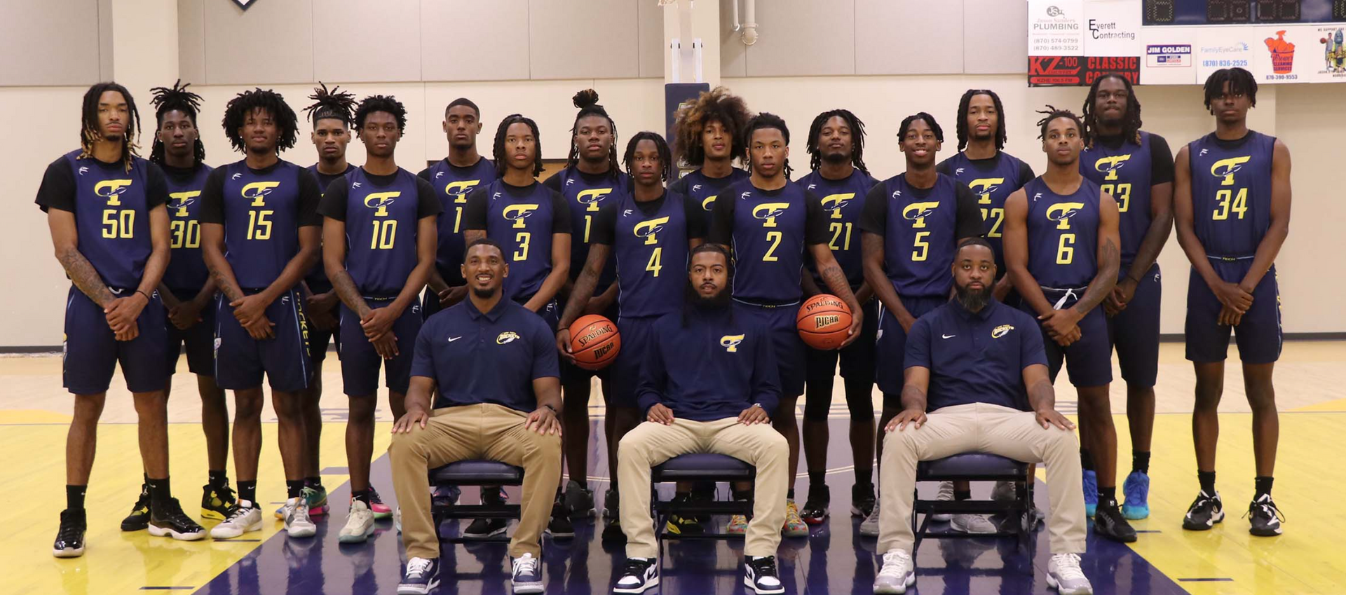 A basketball team is posing for a picture on a court.