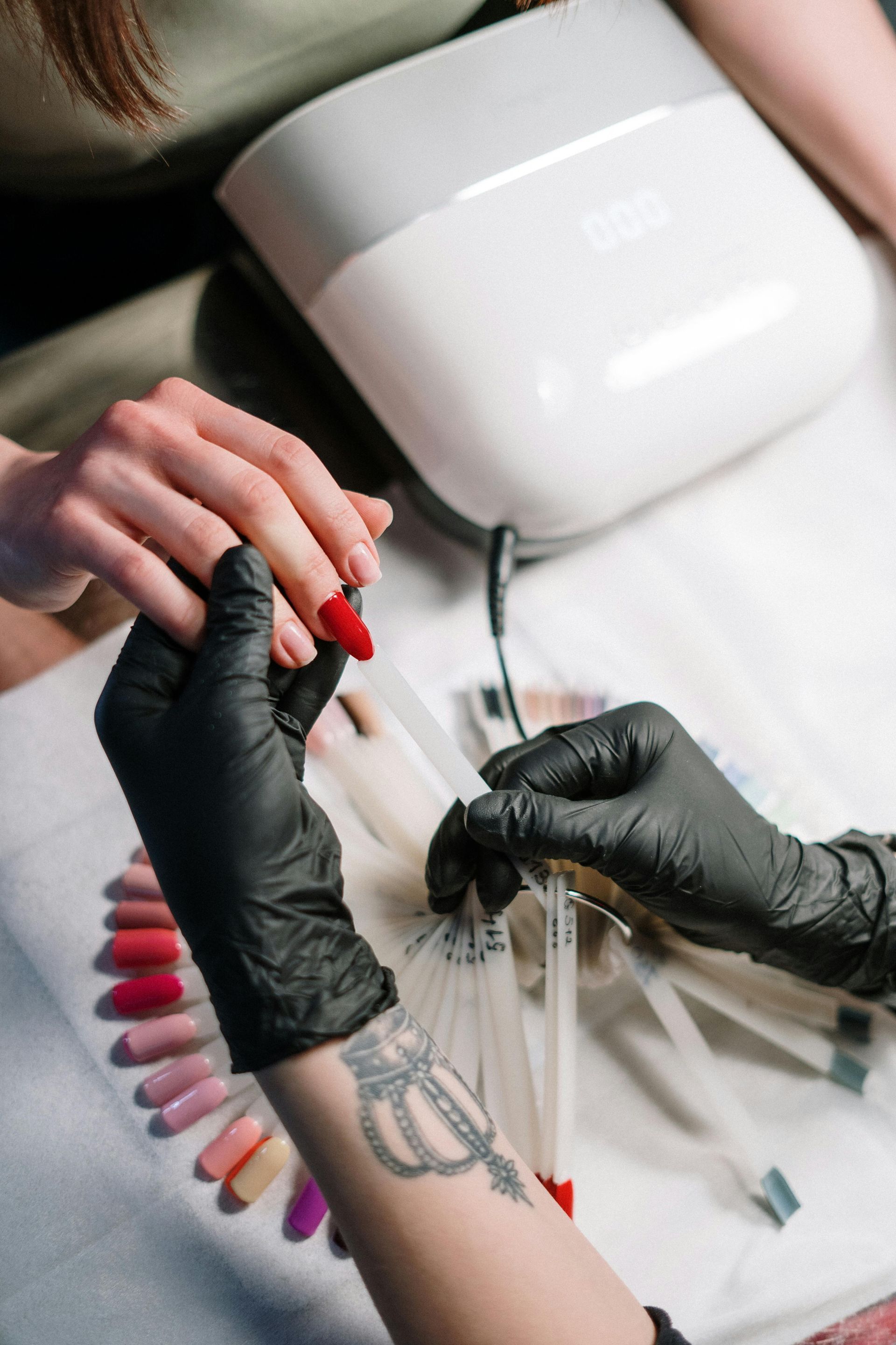 A woman is getting her nails painted by a nail artist.