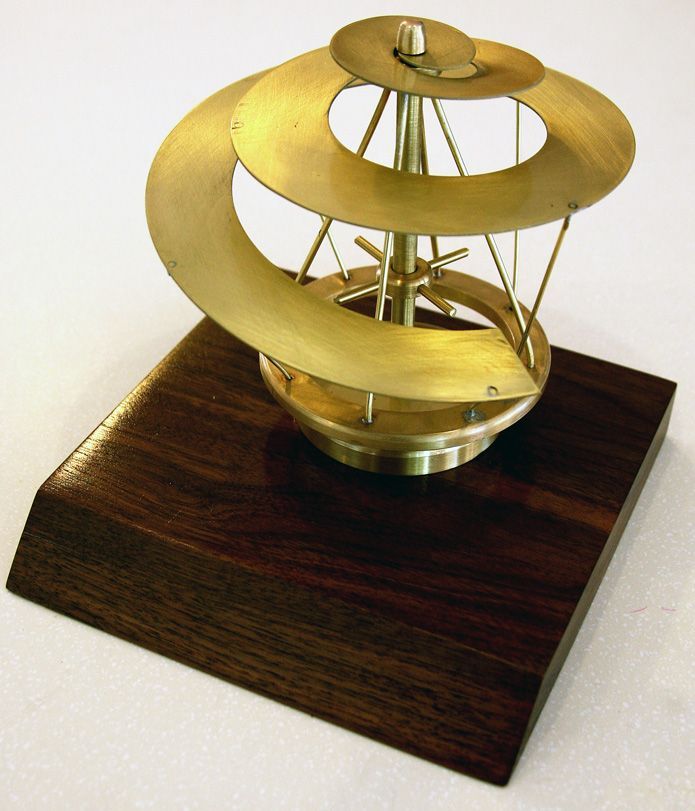 A brass object is sitting on a wooden base