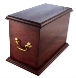 A wooden box with a gold handle on the side