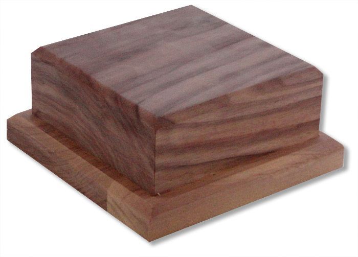 A square piece of wood sitting on top of a wooden base