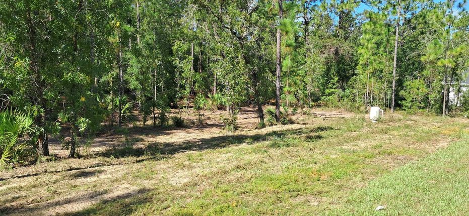 A white truck is parked in a parking lot next to a building.
