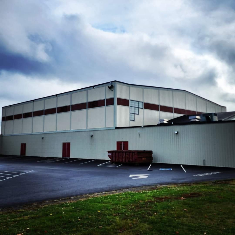 A large white building with a red stripe on the side