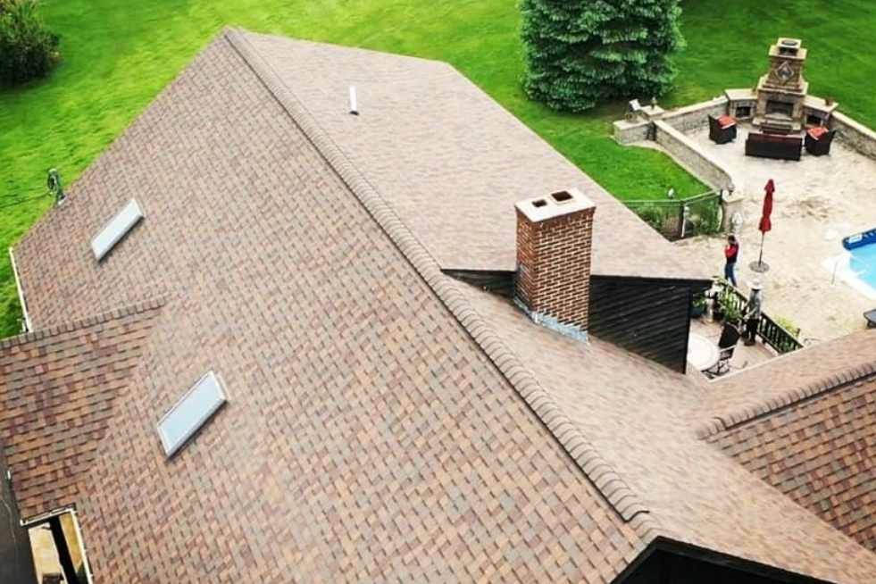 An aerial view of a roof of a house with a fireplace and a pool.