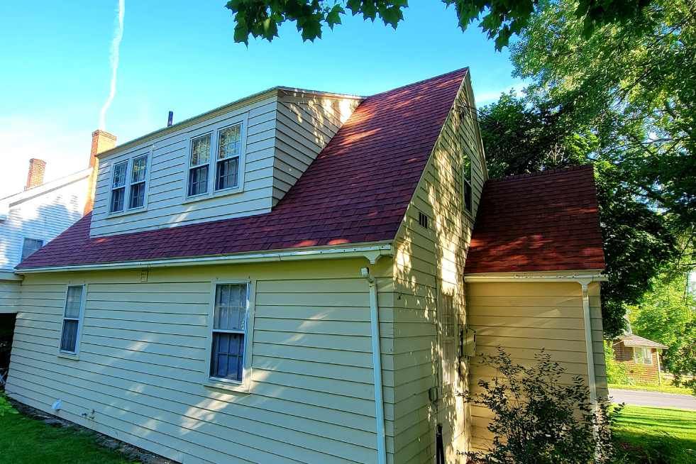 A house with a red roof and a white siding