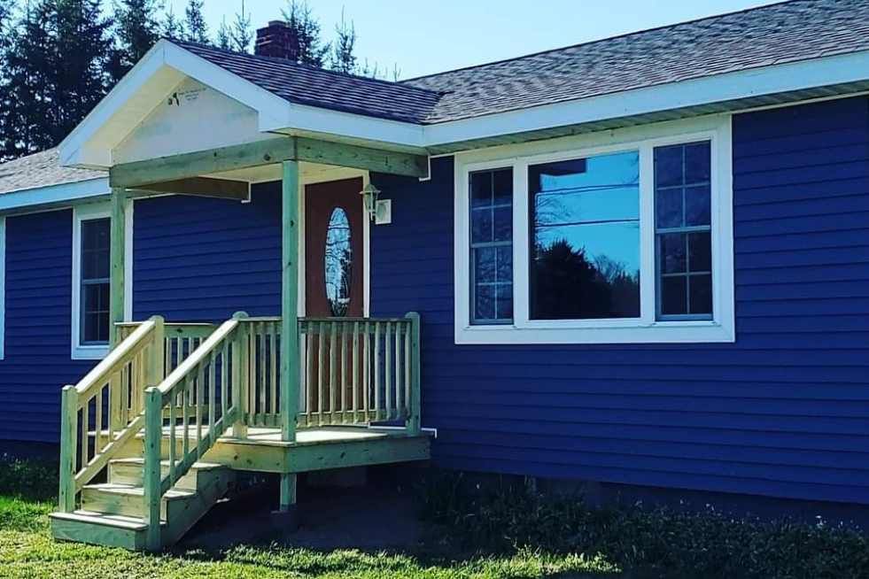 A blue house with a porch and stairs