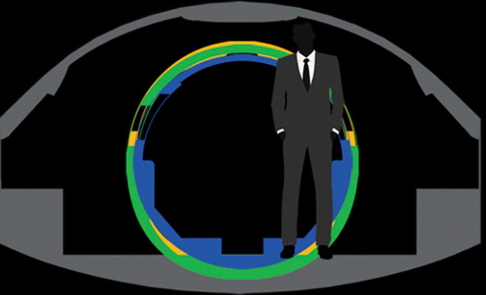 Man in suit stands inside a circular tunnel with blue, green, and yellow rings.